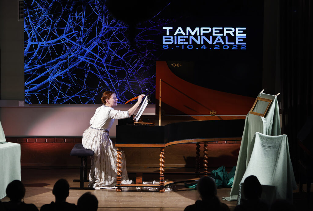 Tilannekuva esityksestä Laura Maddalena. Taustalla Tampere Biennalen logo.