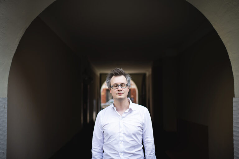 Markku Klami silmät kiinni kaarevan alikulkutunnelin edessä.