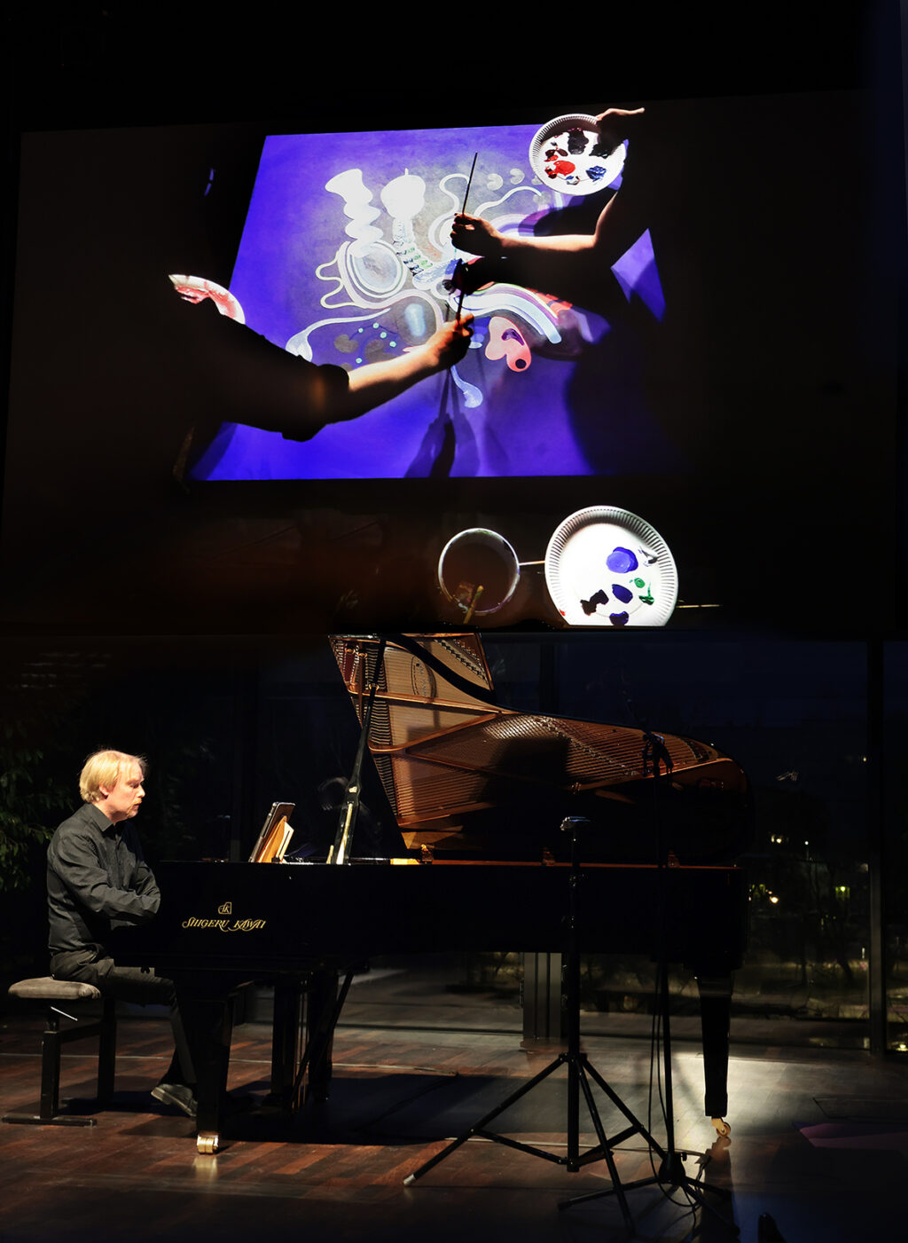 Yllä heijastus livemaalauksesta, alla Ville Hautakangas soittaa pianoa.