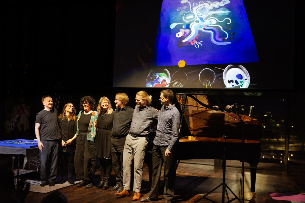 Esiintyjät ja säveltäjät yleisön edessä konsertin jälkeen.